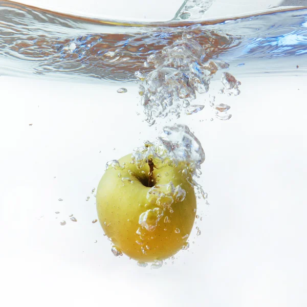 Grüner Apfel unter Wasser mit einer Spur transparenter Blasen. — Stockfoto