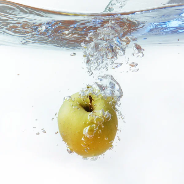 Maçã verde debaixo de água com uma trilha de bolhas transparentes . — Fotografia de Stock