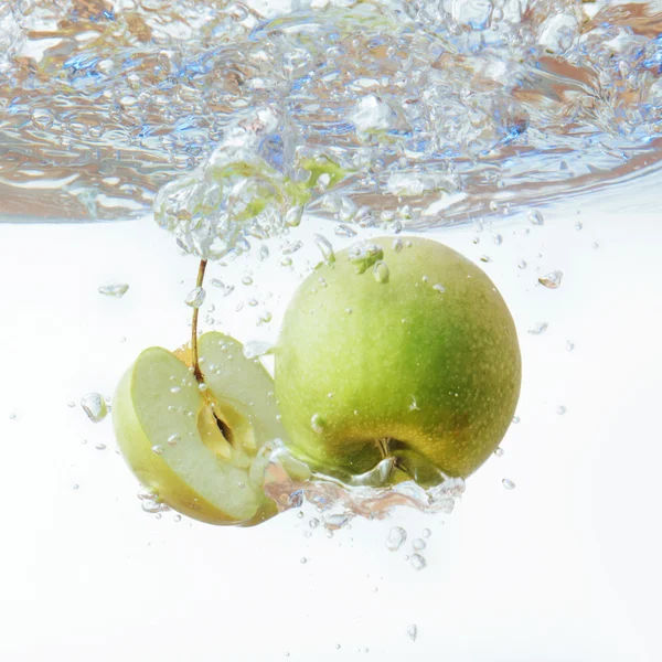 Green apple under water with a trail of transparent bubbles. — Stock Photo, Image