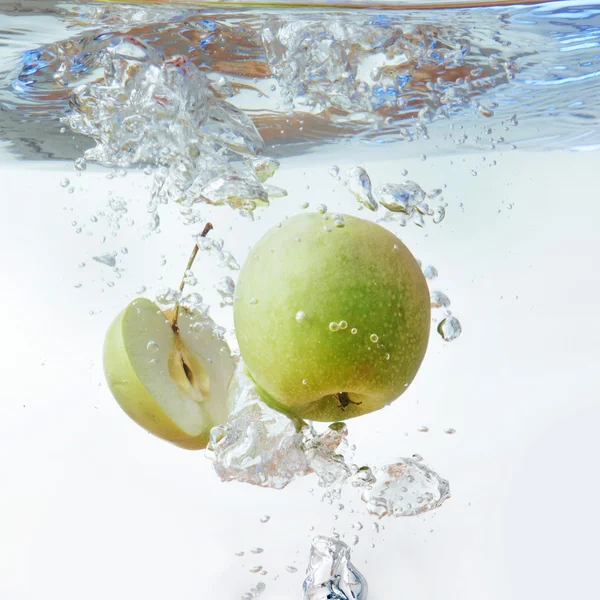 Grönt äpple under vatten med ett spår av transparenta bubblor. — Stockfoto