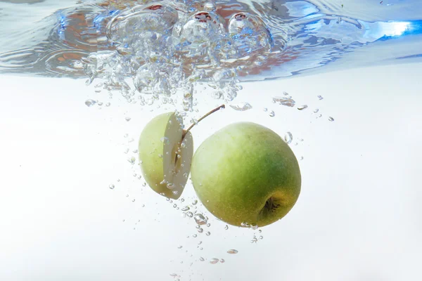 Green apple under water with a trail of transparent bubbles. — Stock Photo, Image