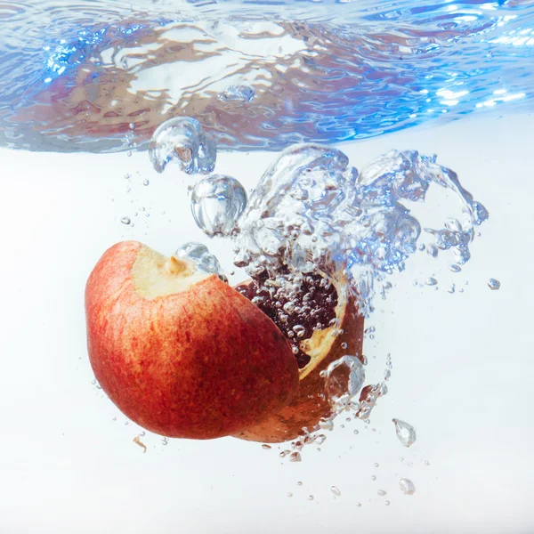 Granato in acqua su fondo bianco — Foto Stock