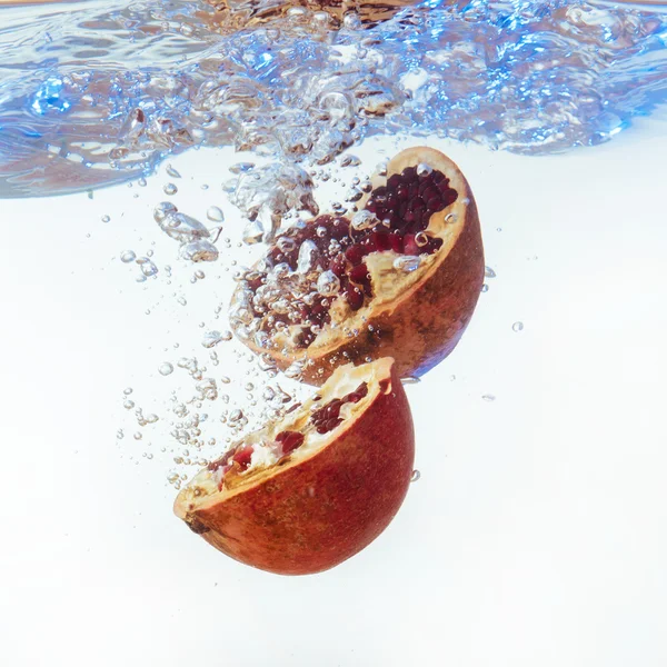 Granate en el agua sobre un fondo blanco —  Fotos de Stock