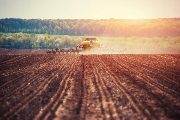 Trattore aratura campo agricolo in preparazione per la semina primaverile . — Foto Stock