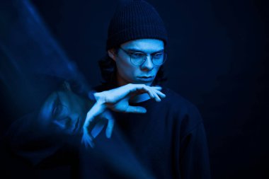 Sinema etkisi. Stüdyo karanlık stüdyoda neon ışıkla çekiliyor. Ciddi bir adamın portresi..