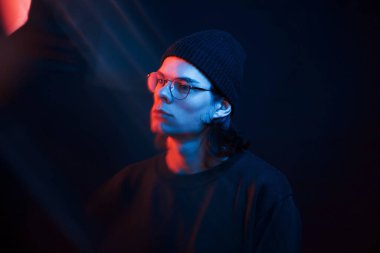 Güzel yansımalar. Stüdyo karanlık stüdyoda neon ışıkla çekiliyor. Ciddi bir adamın portresi..