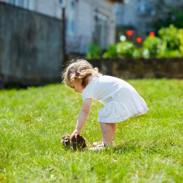 Kind met een konijn op het gras — Stockfoto