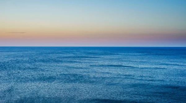 Cloudy sky leaving for horizon above a blue surface of the sea — Stock Photo, Image