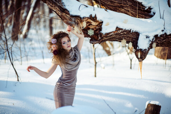 Fashion shoot of young beautiful girl in the winter forest