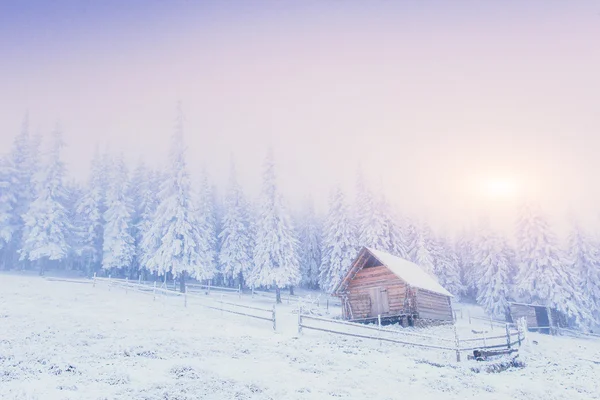 Pôr do sol nas montanhas de inverno e chalé fantástico — Fotografia de Stock