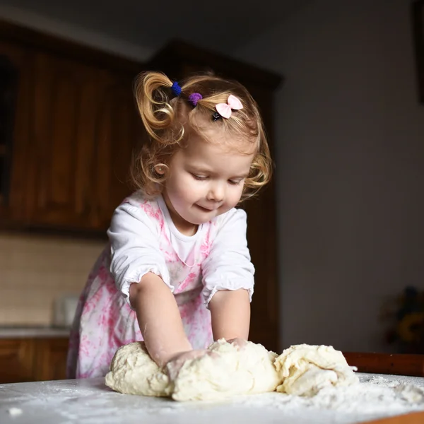 Pretty little girl having fun kneads dough — Stock Photo, Image