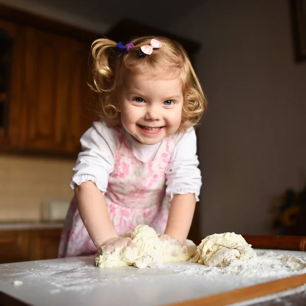 Pretty little girl having fun kneads dough — Stock Photo, Image