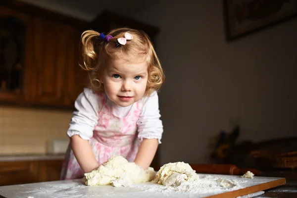 Pretty little girl having fun kneads dough — Stock Photo, Image