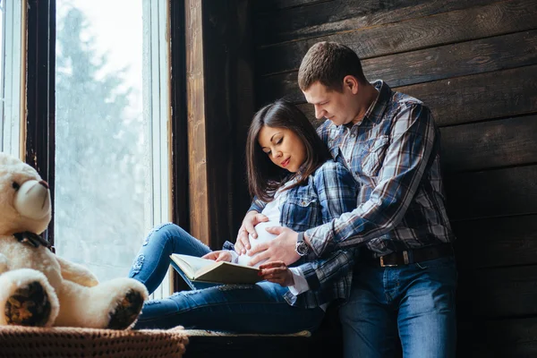 La pareja feliz al ver el libro . —  Fotos de Stock