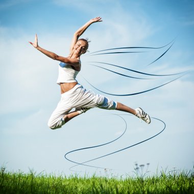 Yeşil çimenlerin üzerinde germe egzersiz yaparak güzel bir genç kadın bir