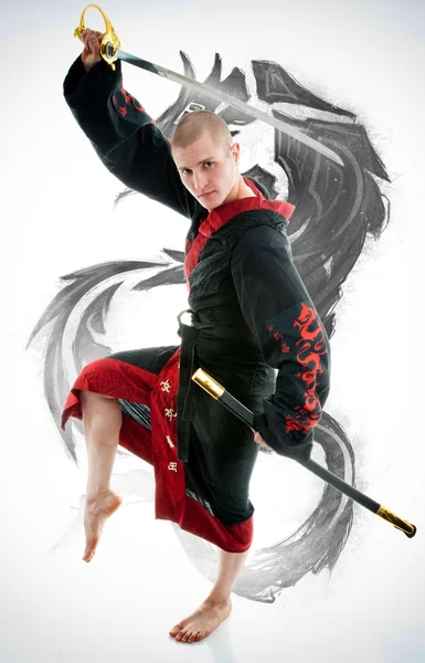 Man dressed in black dragon kimono demonstrating martial arts co Stock Image