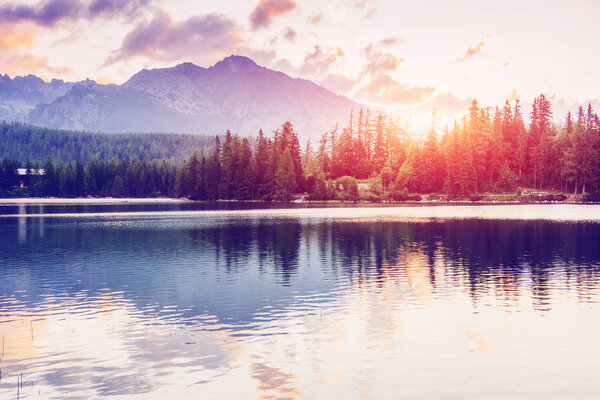 The sunrise over a lake in the park High Tatras. Shtrbske Pleso