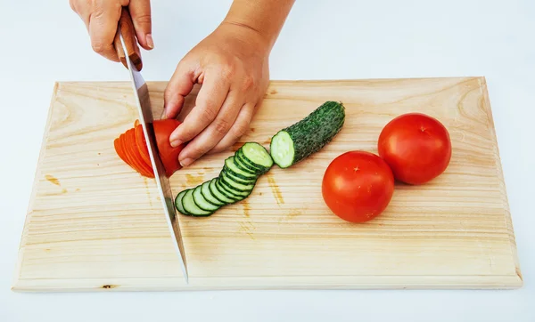 Gesneden tomaten en komkommers op houten plank. — Stockfoto