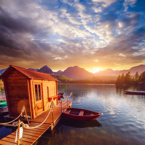 Bateau sur le quai entouré de montagnes. Fantastique Shtrbske Pleso — Photo