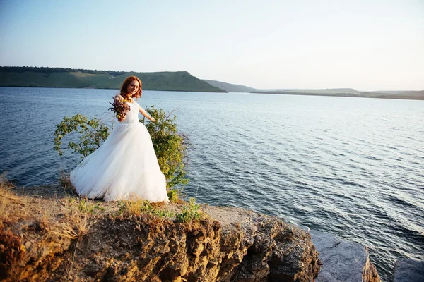 Underbar blondin på klipporna, mitt i havet — Stockfoto