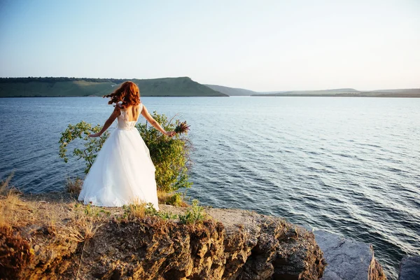 Underbar blondin på klipporna, mitt i havet — Stockfoto