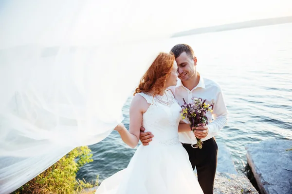 Splendida bionda sposa e sposo di classe sulle rocce, in mezzo al se — Foto Stock