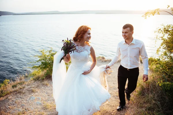 Bella bella bella bionda sposa e sposo di classe sulle rocce, ami — Foto Stock