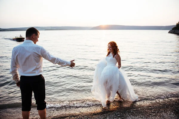 Γαμήλιο ζεύγος στο νερό στο ηλιοβασίλεμα — Φωτογραφία Αρχείου