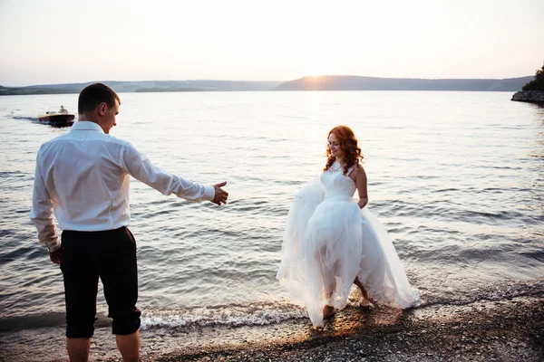 Boda pareja en el agua al atardecer — Foto de Stock