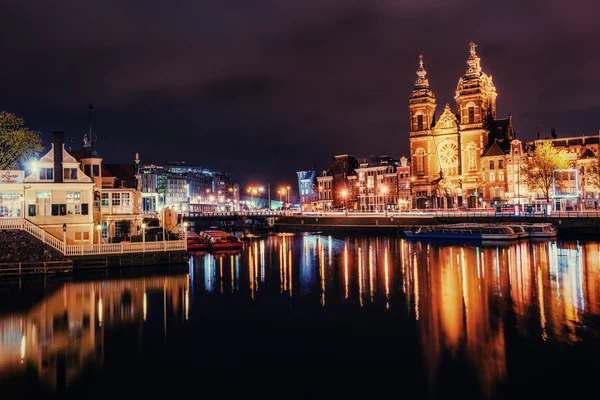 Hermosa noche en Amsterdam. Iluminación nocturna de edificios y — Foto de Stock