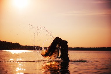 gün batımında su arka plan üzerinde kadın