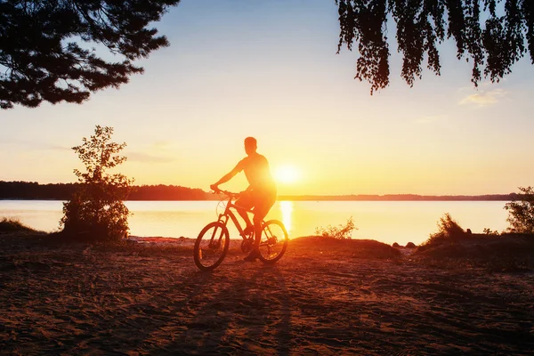 Jongen op een fiets bij zonsondergang — Stockfoto