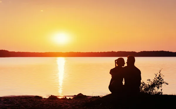 Coppia romantica sulla spiaggia al tramonto colorato sullo sfondo — Foto Stock