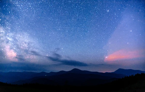 Astrofoto do céu profundo. Fantástica chuva de meteoros de inverno e montanhas cobertas de neve — Fotografia de Stock