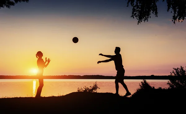 Coppia in gioco al tramonto in riva al lago — Foto Stock