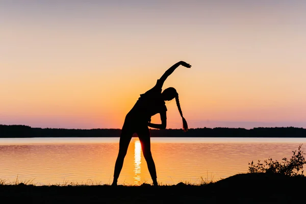 Ragazza al tramonto in riva al lago — Foto Stock