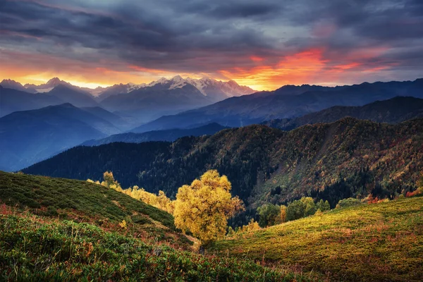 Sunset over snow-capped mountain peaks. The view from the mounta — ストック写真