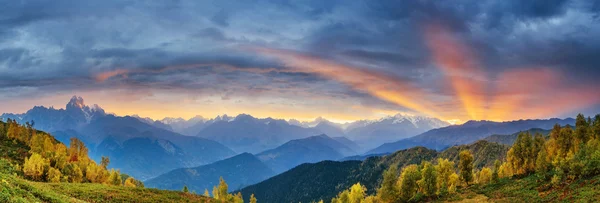 Pôr do sol sobre picos de montanha cobertos de neve. A vista da montanha — Fotografia de Stock