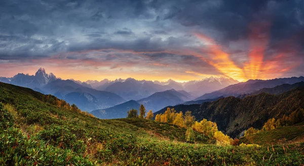 Sunset over snow-capped mountain peaks. The view from the mounta — Stockfoto