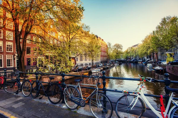 Fietsen geparkeerd langs een brug Over de grachten van Amsterdam, Net — Stockfoto