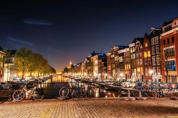 Bicicletas estacionadas ao longo de uma ponte sobre os canais de Amsterdã, Net — Fotografia de Stock