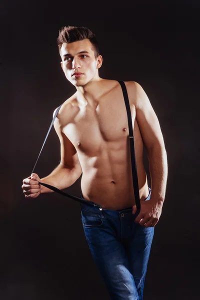Retrato de um homem com nude torso fitness de pé em jeans com — Fotografia de Stock