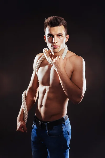 Un joven con un torso y una cuerda desnudos . — Foto de Stock