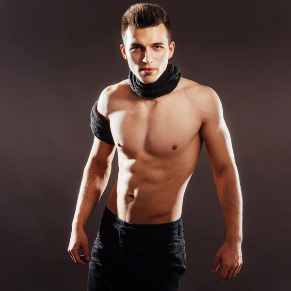 Sexy young man with a naked torso on a dark background — Stock Photo, Image