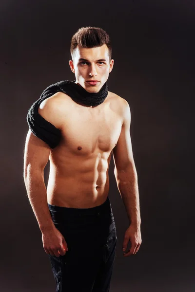 Sexy young man with a naked torso on a dark background — Stock Photo, Image