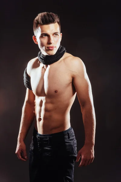 Sexy junger Mann mit nacktem Oberkörper auf dunklem Hintergrund — Stockfoto