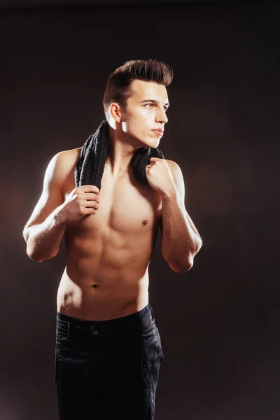 Sexy young man with a naked torso on a dark background — Stock Photo, Image