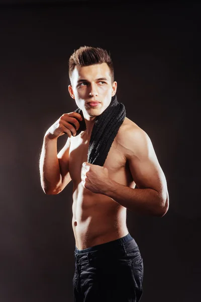 Sexy young man with a naked torso on a dark background — Stock Photo, Image