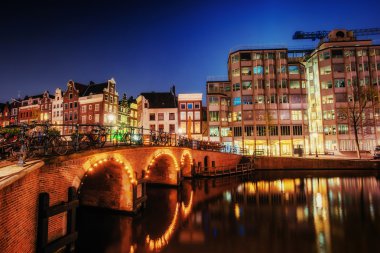 Amsterdam'da gece kanal. Binaları ve sokakları vurgulama 