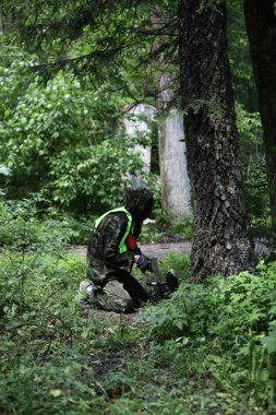 ormanda amaçlayan paintball oyuncu
